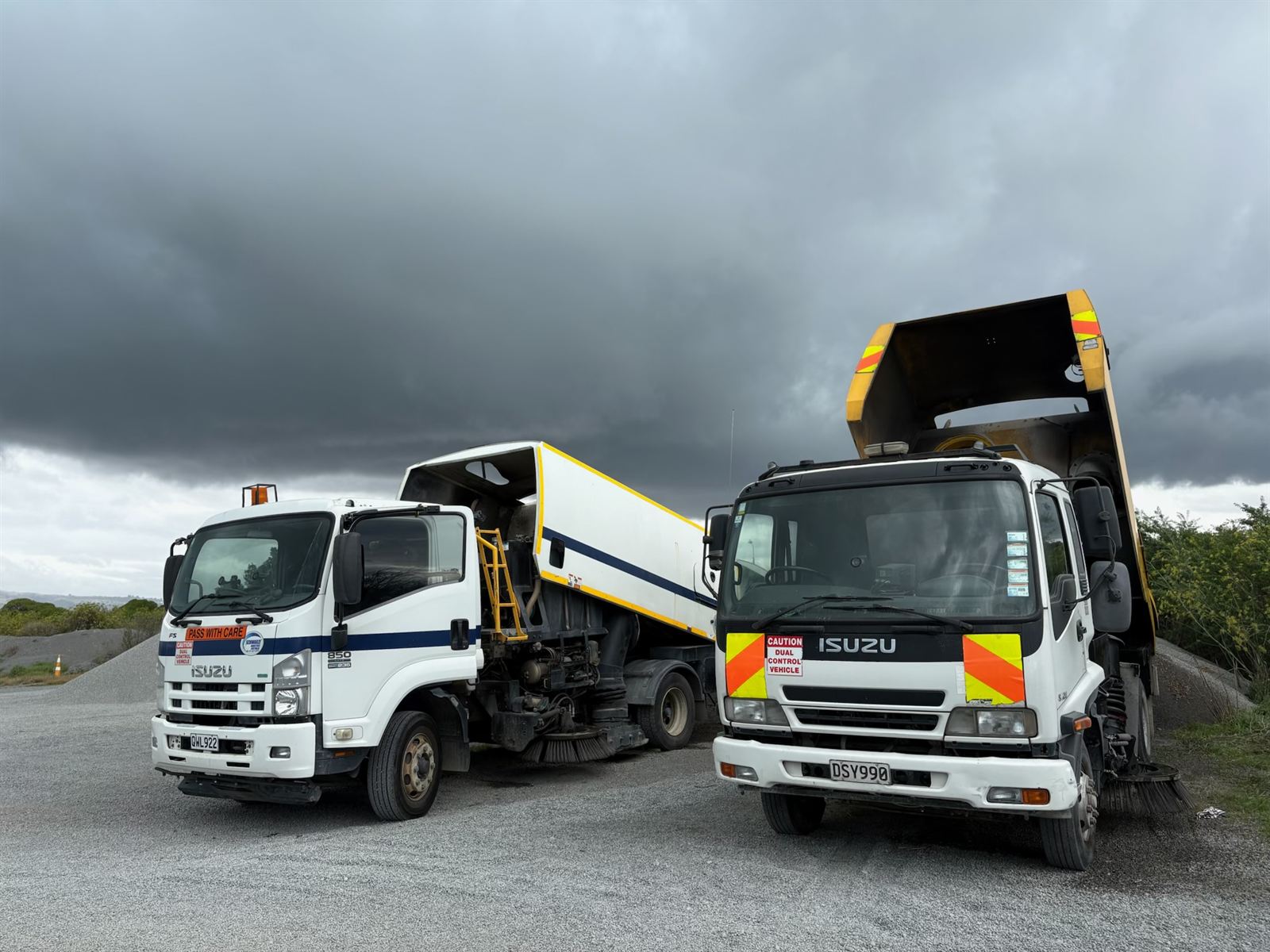 The HSS Ltd fleet — Isuzu road sweeper and tipper trucks in the yard